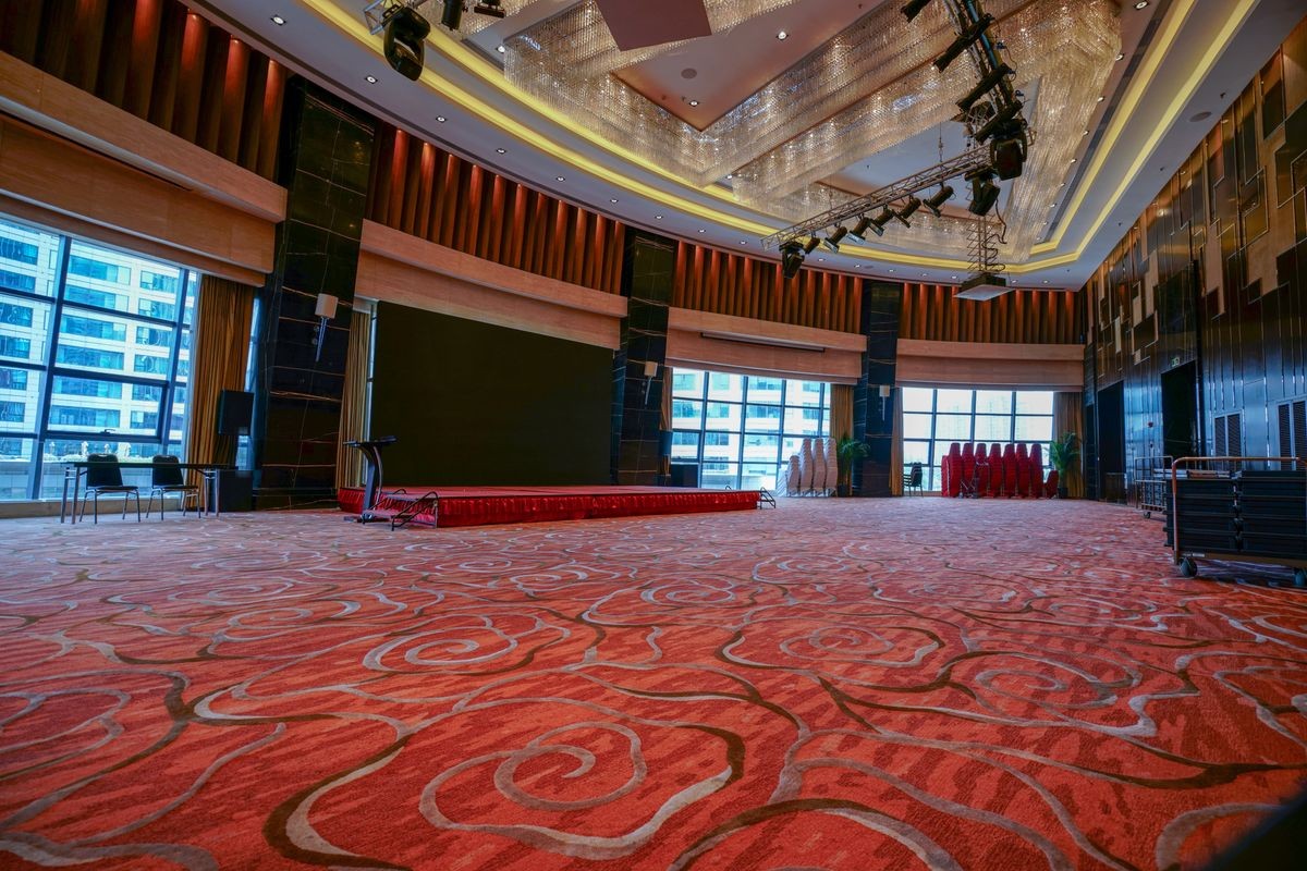 Huge Hall interior with red carpet and ceiling with crystal lights in Hotel.
